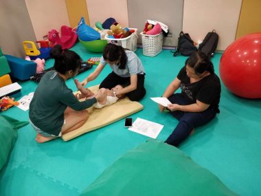 massage for children | AADC News | A therapist shows Rylae-Ann's family how to perform massage during a sensory integration therapy session.
